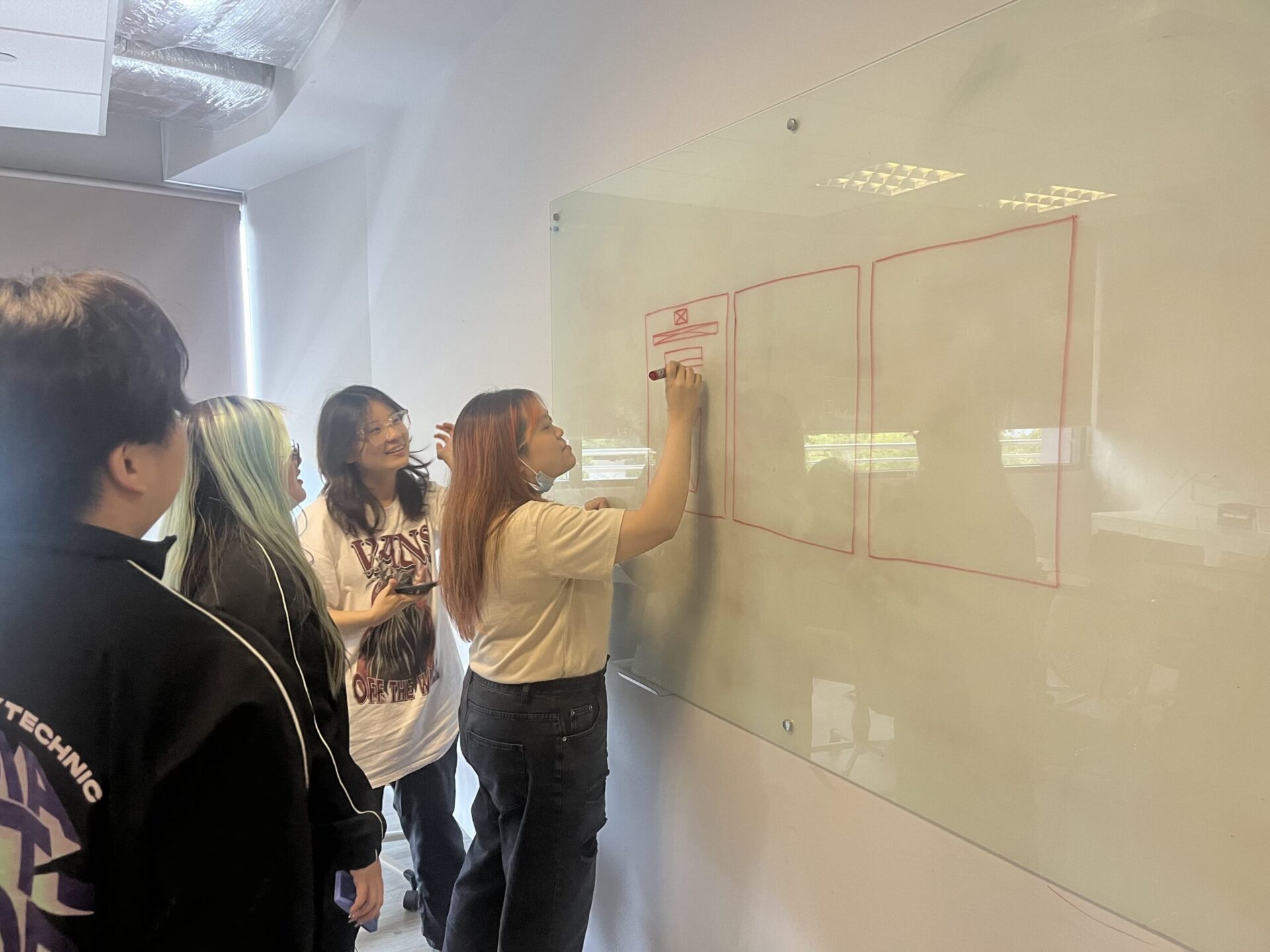 A member of the team is writing some notes on the whiteboard