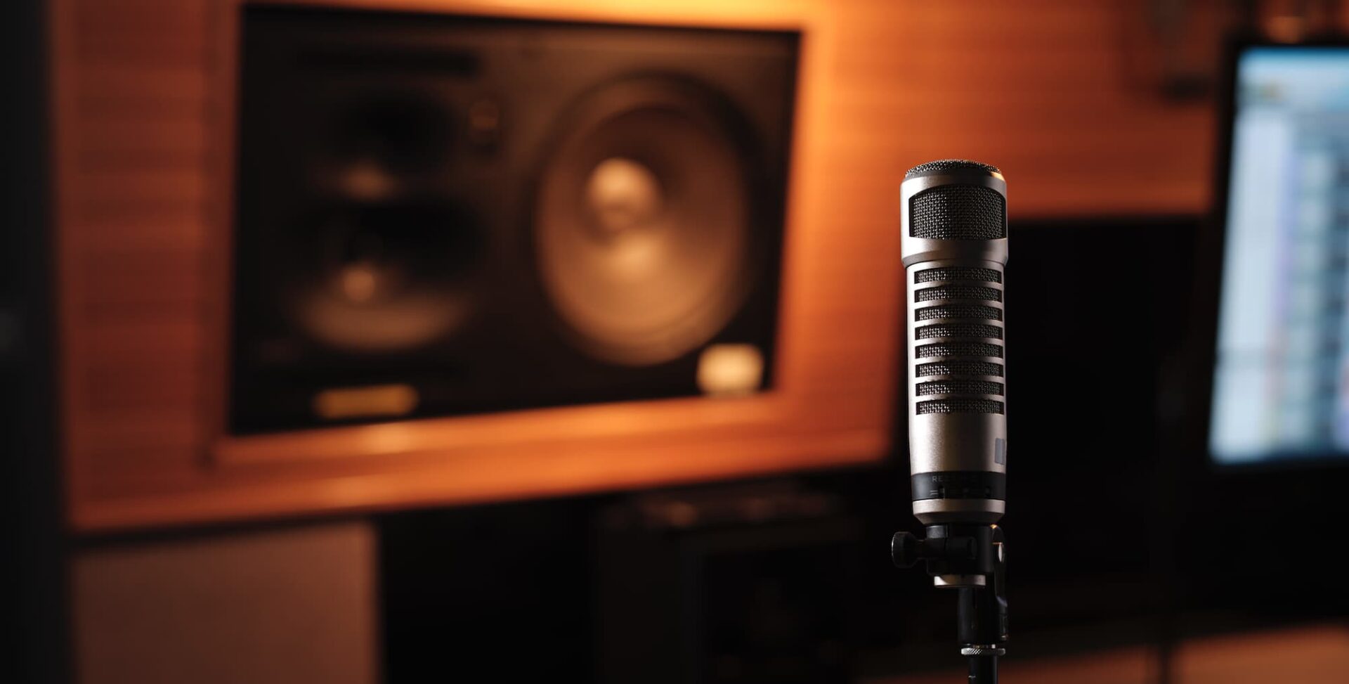 A warm image of a microphone in a studio that acts as a hero image for Mass Communication diploma.